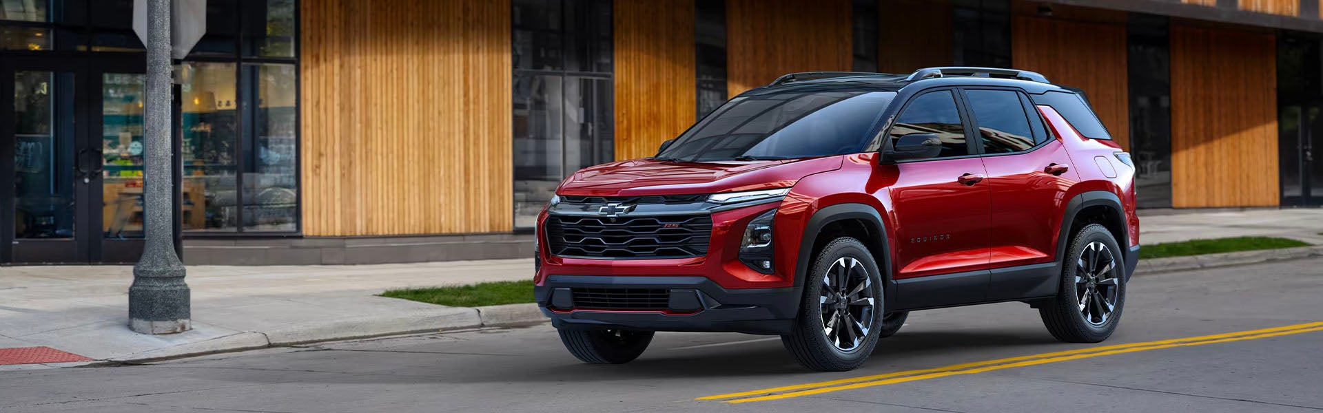 A red 2025 Chevy Equinox driving down the road.