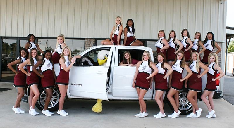 team group photo near car